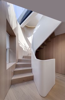 10 Dazzling Modern Staircases - Photo 8 of 10 - On a triangular site in the Fitzrovia neighborhood of London, architecture firm FORMstudio created an irregularly shaped stair with treads and risers that match the wide-planked, white oak floors. A thick acrylic banister winds alongside the stair like a matte-white ribbon. Together, the white oak and acrylic have a distinctly calm, Scandinavian feel about them.