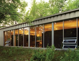 Floor-to-ceiling windows capture natural light and warmth while offering expansive views of the woods to the south. "In the winter, I like to use the house as therapy because there’s so much light," Cook says.