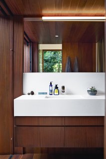 The couple chose to contrast the wood in the master bath with a smooth Caesarstone counter in Organic White 4600, which was measured and cut specifically for the space. They added a bit of shine with polished-nickel Upton fixtures from Toto. Photo by Coral von Zumwalt.