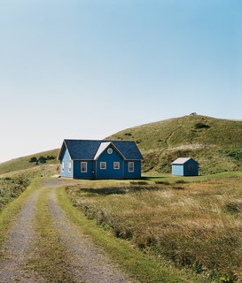 A small deck off the back of the main house is protected from the wind and supported by a small grassy mound.