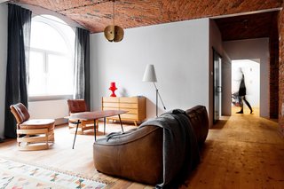 By burnishing historic details and adjusting the floor plan, multidisciplinary studio Loft Szczecin restored and transformed a loft in a warehouse that dates from before World War II. The living room rug is a Polish textile from the 1930s.