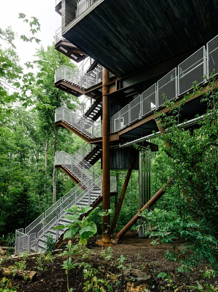 Mithun designed the tree house so that it would tread lightly on the land. The firm originally considered prefabricating the entire structure offsite but, in the research process, concluded that craning large modules into place would potentially harm the canopy. A combination of a bolted-together prefab structure and site-built wood housing yielded the least intrusive construction option.
The Summit Bechtel Reserve is located in West Virginia's coal mining country. The architects looked to the local structures—bridges, mining apparatus, and other industrial buildings—to inform the tree house's design. A 166-ton Cor-Ten steel megastructure supports the 125-foot-tall building. The use of regionally appropriate materials, like steel and black locust wood, was important to the architects. Photo 3 of Sustainability Treehouse modern home