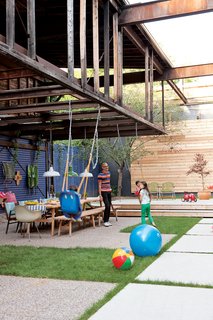 The courtyard is an extension of the house, with a big table that hosts parties, a stage for impromptu performances, and part of an old loft overhead that will one day become a treehouse for the children. Photo by Stacey Brandford.