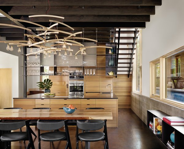 “We wanted to bring the outside in with the warmth of the materials,” Flato says. “A custom dining table and shelving were designed and built from a pecan tree that had fallen on the site.” Vertical grain Western red cedar, the same material used for the exterior siding, was also used to create custom kitchen cabinets. Photo 3 of Hog Pen Creek modern home