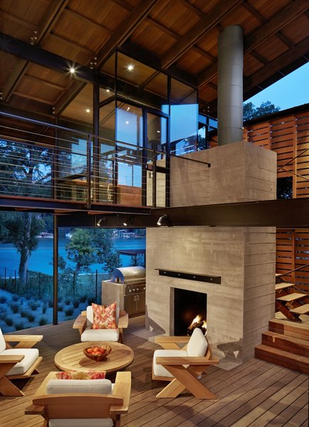 The owners’ main living area has two stories with a master bedroom, which can be accessed by a rolling door, and porches on either end of the structure. “This large, barn-like building, with its moveable bedroom wall and office, allows the house to be both intimate and social, effortlessly accommodating guests or individuals alike,” Flato says. Photo 5 of Hog Pen Creek modern home