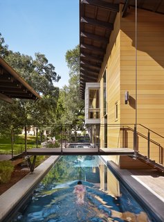 "The owners envisioned a place that engaged with the outdoors while providing accommodating spaces for their off-season training for triathlons," Flato notes. A 75-foot-long lap pool on the west end of the home comes in handy during practice.