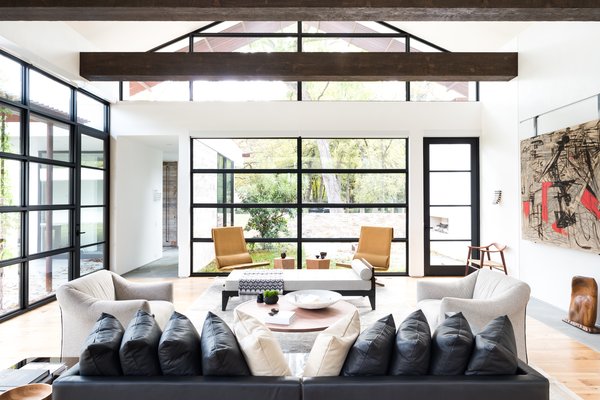 For this project, the husband loved ultra-modern design, while the wife leaned towards a more traditional aesthetic. How to please both? “Through the design process, we learned that their tastes were actually more closely aligned when we focused on the desired 'feel' of the home versus specific design details,” Field says.
He and his colleagues balanced rustic, exposed ceiling beams with elegant venetian plaster walls, and artful aluminum storefront windows with functional white oak plank flooring. Photo 3 of Preston Hollow modern home