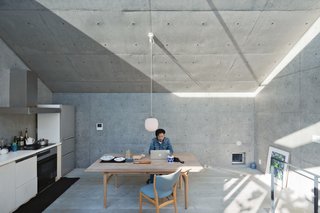 Nakada works from an Alvar Aalto table in the living and dining area, adjacent to the kitchen. He saved on some elements, such as the plywood cabinetry, and splurged on others, such as the Finn Juhl chairs and Vilhelm Lauritzen lamp. A skylight beneath the angled roof allows in a sliver of constantly changing light.