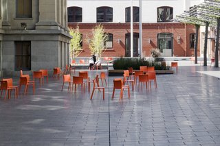 Mint Plaza in San Francisco used to be a highly sketchy back alley. Today it's a vibrant public pedestrian plaza and festival space lined with restaurants and cafes, filled with dozens of movable bright orange chairs and shaded by a vine-covered steel trellis.