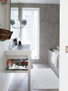 Early on in the design process, Church had to forgo her fantasy of concrete floors with radiant heat and a cast-concrete sink. But her gray-tiled bathroom satisfies her concrete-loving aesthetic at a much lower price point.