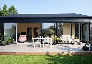 30 All-Black Exterior Modern Homes - Photo 11 of 30 - Since the front door is located in the exterior wall, residents first enter a vast garden before reaching the gable roof house.