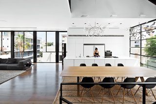 The Complete Dwell Guide to Eames Shellspotting - Photo 7 of 9 - The fourth-floor kitchen of this family home in Tel Aviv features Heracleum II pendants by Bertjan Pot for Moooi that hang over both the kitchen island and the dining table. Eames shell chairs surround the table.