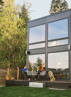 A Home's Past Mistakes Are Finally Corrected - Photo 1 of 14 - Sally Julien and Peter Loforte sit on the porch of the Aqua Lair, their restored 1960s house on Lake Sammamish, near Seattle. The Bertoia chairs and clay lion are from Pacific Galleries.