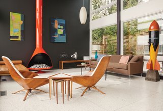 Two Seattle homeowners remade a soggy midcentury home as a thoroughly modern masterpiece by punching up vintage numbers with bold color. A pair of vintage George Mulhauser for Plycraft chairs is complemented by a powder-coated orange fireplace, a coffee table by Alexander Girard for Knoll, and a pair of undated paintings by Arthur L. Kaye.