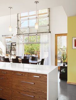 Cost-Effective Family Home in Pittsburgh - Photo 2 of 8 - A Batons chandelier from LBL Lighting hangs over the dining table. A garage-style door by Overhead Door opens onto a patio that gets plenty of use when the weather cooperates.