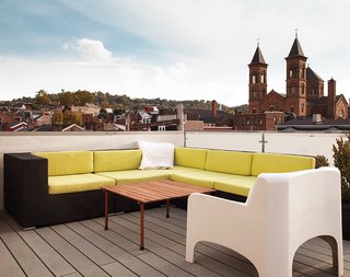 Cost-Effective Family Home in Pittsburgh - Photo 5 of 8 - The roof deck, with views of the nearby St. Augustine church and beyond to downtown Pittsburgh, features partially recycled plastic decking from Rhino Deck and a custom galvanized-steel railing with frosted Plexiglas panels. "Pittsburgh’s one of those cities that if you grew up here, it has a draw that pulls you back," Moss says.