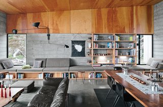 Norman Millar and Judith Sheine designed the built-ins in the living-dining area, which were made from vertical-grain Douglas fir. Vintage Dutch industrial chairs are arranged around a black walnut dining table that, like the madrone coffee table, is by Urban Hardwoods.