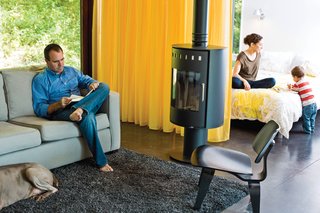 A Rais Pina wood-burning stove keeps things cozy on the West Elm Henry sofa and Eames lounge chairs.