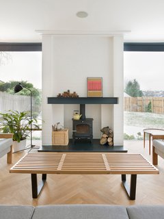 In the living room, a Nelson bench doubles as a coffee table, and a wood-burning stove from Cleanburn Stoves keeps the space warm.
