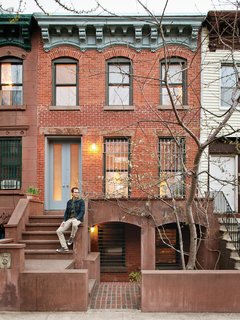 Sherman sits in front of his Prospect Heights home. The front door is made from etched Lexan bulletproof glass.