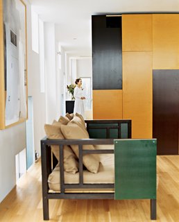 8 Modern Paneled Rooms - Photo 4 of 8 - In the Venice, California, home of architect Lorcan O’Herlihy, operable panels of the built-in cabinetry, in chocolate and caramel colors, offer cues to the color palette of more mobile furnishings. Using the same panel material, the architect customized a West Elm couch for the living room. Photo by Misha Gravenor.