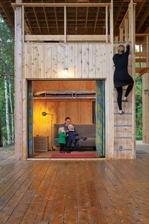 The vacation complex is designed to promote an easy flow between the two families' spaces, which include guest cabins and a shared porch for hanging out and eating.