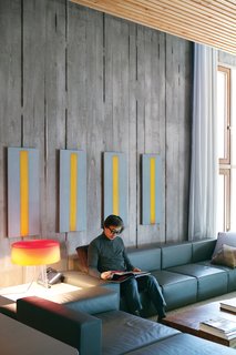Cho relaxes in the first-floor living room, where paintings by up-and-coming Germany-based Chinese artist Ruo Bing Chen play off a sofa and coffee table designed by the architect himself.