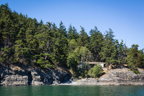 “There had been two or three primitive cabins on the property in the past, which resulted in a clearing that we utilized for the site,” Joseph Herrin says. “This allowed us to avoid any further tree removal for construction, and provided an opportunity to begin to restore that portion of the property with native landscaping.” Photo of San Juan Islands Residence modern home