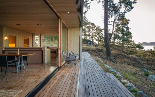 “The layout and openings allow ample flow to the exterior, and paths and decks have been developed to ‘flatten’ the sloping site enough to create generous outdoor gathering areas,” Herrin says. “These areas take into account sunlight at different times of day as well as protection from prevailing wind,” he adds. One-by-six-foot ipe planks comprise the decking, and hemlock end grain by the Oregon Lumber Company was installed indoors. Photo 5 of San Juan Islands Residence modern home