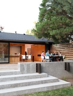 IKEA chairs join a table from CB2; a Kawneer triple-sliding door opens to the family’s new ipe deck.