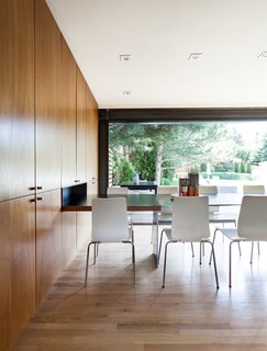 Of the Caesarstone counter, which extends to a built-in steel dining table with a detachable leaf, he says, "The total length is just over 16 feet, which gives it a really beautiful, sleek proportion." Chairs are from IKEA.