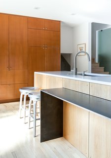 The dining table narrows to a counter attached to the island.