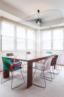 In the Tribeca penthouse of a young bachelor, Reddymade Design kept most of the space intact, focusing on adding bright and appealing furniture and materials. Tropicalia chairs from Moroso surround an El Dom table from Cassina. The pendant is from Petite Friture.