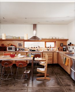 In the kitchen, a window over the stovetop lets daylight in, framing the front yard while keeping the neighboring house out of the picture.