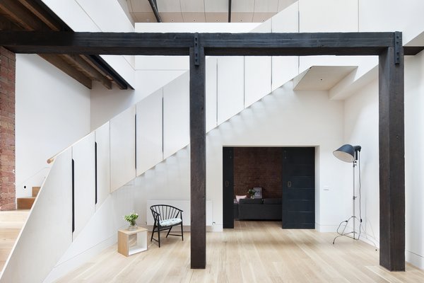 “To draw light and ventilation into what was a poorly oriented and deep footprint, an extensive number of operable skylights were introduced on the north- and south-facing roof pitches, and a large void connecting the floors was strategically positioned to also take advantage of this amenity,” Simpson says. American oak floorboards and Dulux paint were used throughout the property for continuity. Photo 2 of Water Factory modern home