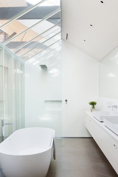 “A critical aspect of the project was the incorporation of natural light and ventilation within a broad footprint,” Simpson says. Conventionally private areas, like bedrooms and bathrooms, are therefore reinterpreted with more openness in mind. For instance, this bathroom’s skylights mirror those found throughout the rest of the property. The bathtub, basins, and showerhead were all purchased at the Australian retailer Reece. Photo 8 of Water Factory modern home