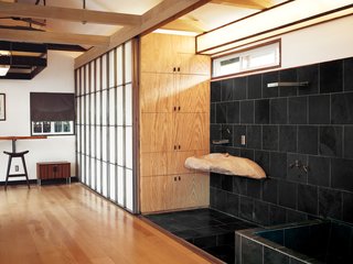 Custom shoji-inspired screens of Roberts’s design conceal the closet and extend to provide privacy for the adjacent shower and soaking tub.