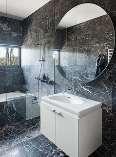 The marble continues in a bathroom, which has a Palomba sink from Laufen.