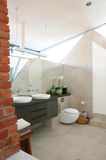 Sinks and a toilet from Laufen’s Il Bagno Alessi line add a sculptural presence to the master bathroom.