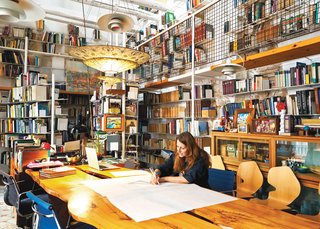 In her library, Tagliabue works at a table designed by Miralles.