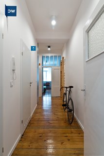 Our Dorm Definitely Did Not Look Like This - Photo 2 of 7 - The subdued white and grey interiors help highlight details such as the flat's original wood floors. Apart from the blue bathroom identifiers and room markers, the only other colors used are the occassional orange and green, the same hues that are used in several of Wierciński’s other projects.