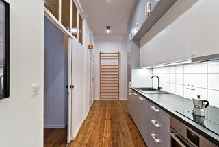Our Dorm Definitely Did Not Look Like This - Photo 3 of 7 - Working within the constraints of a modest budget, the design team creatively mixed custom-designed pieces with more affordable items. For example, the shared kitchen features a Franke kitchen sink and IKEA cabinetry and appliances. Framing the kitchen wall, an old gymnasium ladder adds an historical touch. The biggest challenge of the project, says Wierciński, was to "execute a low budget project with a unique original style."