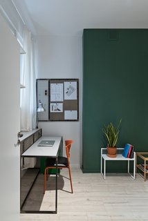 Our Dorm Definitely Did Not Look Like This - Photo 5 of 7 - One student bedroom features the second green accent wall. Each bedroom is about 140 square feet and includes places for sleeping and studying, plus built-in IKEA wardrobes. The custom desk is paired with an orange IKEA chair. The small metal accent table and magnetic wall board are also by Wierciński.