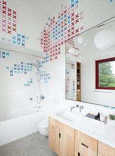 Husband-and-wife ceramic artists, Dear Human, baked x-shaped decals into store-bought Olympia Tile before arranging them in the kids’ bathroom. The tub is by Bette and the sink, set in a Corian countertop, is by Duravit.