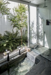 Our Editor Sets the Kitchen and Bath Benchmark - Photo 6 of 6 - Located in a forest in the Andean foothills, this house draws from the region’s geology to produce a unique bathing experience. The bathroom is poured-in-place concrete surfaced in laja stone, a local material chosen by the architect to evoke the region’s thermal baths. The space opens to a private garden via two doors—one in the shower, the other behind the toilet. The shower fittings are from Paini.