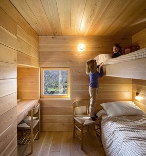15 Modern and Creative Spaces For Kids - Photo 15 of 15 - The kids' room is wrapped in wood and features built-in bunk beds for a relaxed and cozy camp vibe. It's outfitted with built-in bunk beds.
