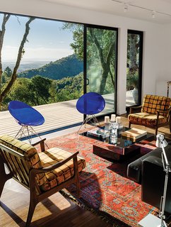 In the living room, interior designer Meredith Rebolledo of Ma(i)sonry Napa Valley paired pieces like Philippe Starck’s Eros chairs for Kartell and two 1960s Swedish chairs with the client’s Oushak rug.