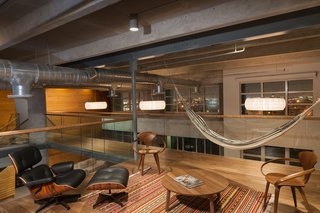 A Miami Renovation That Blends Concrete and Rich Wooden Interiors - Photo 5 of 7 - A classic piece like this Eames lounge chair appears dressed down next to a hammock in the office space. Also featured are wooden office chairs by Norman Cherner.