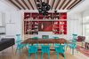 A quartet of red paints (Raspberry Truffle, Million Dollar Red, Vermillion, Arroyo Red), all by Benjamin Moore, make the built-in shelving in the dining area pop. The table is a custom design made of bookmatched walnut slabs joined by lacquered butterflies. The chairs are vintage Paul McCobb lacquered in turquoise (Benjamin Moore's Aruba Blue). The Ligne Roset Ruché sofa, designed by Inga Sempé, separates the living and dining spaces. The chandelier is by David Weeks Studio. Photo 2 of Color Splash modern home