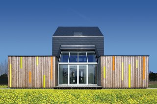 The sun shines over the meadow on the backside of Kuczia’s carbon-saving creation, whose central atrium contains the living room. In summer, the glass doors open.